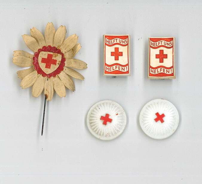 Fünf Abzeichen des Winterhilfswerk. Alle zeigen das Logo des Roten Kreuzes.