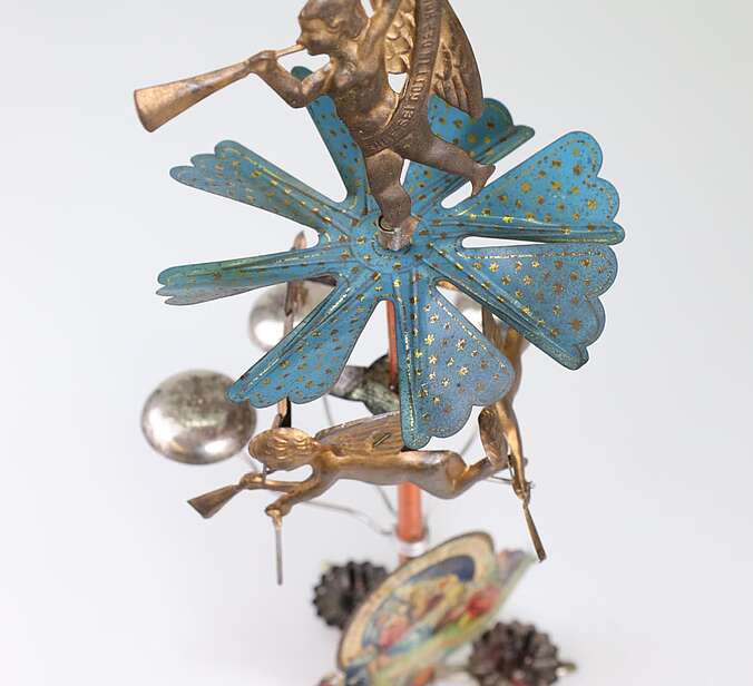 Ein Engelsgeläut aus Blech. Es ist von oben herab fotografiert, sodass man den blauen Propeller gut sehen kann.