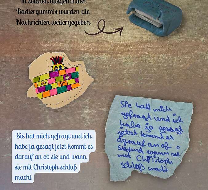 Ein kleines blaues Radiergummi, das ausgehöhlt wurde um Zettel zu transportieren, Eine Schülerzeichnung, ein beschriebener Zettel.