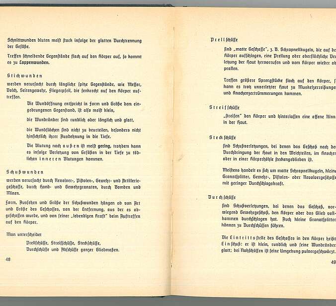 Eine aufgeschlagene Seite des Buchs "Amtlichen Unterrichtsbuch über erste Hilfe". Es geht um die Behandlung von Schussverletzungen.
